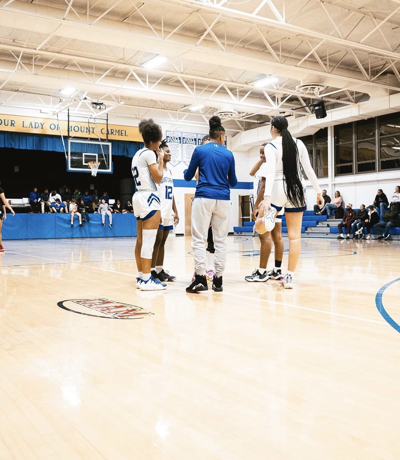 Coach Nay talking with her players on the court